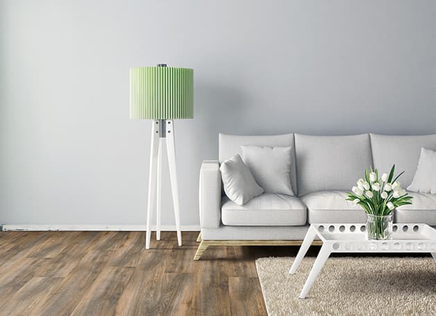 fresh basement living space with wood-look vinyl flooring, soft beige rug and a white sofa